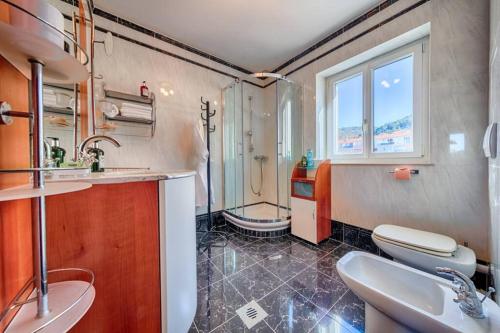 维斯Seafront Apartment Duo的一间带两个盥洗盆、淋浴和卫生间的浴室
