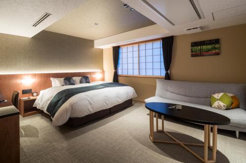 京都Homm Stay Nagi Arashiyama Kyoto By Banyan Group的酒店客房,配有床和沙发