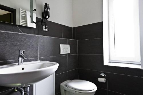 比勒费尔德1,5 Zimmer City-Apartment-Bielefeld的黑白浴室设有水槽和卫生间