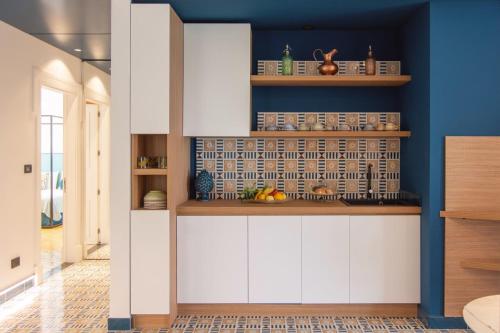 维克艾库塞B&B Nicotera29的厨房配有白色橱柜和蓝色的墙壁