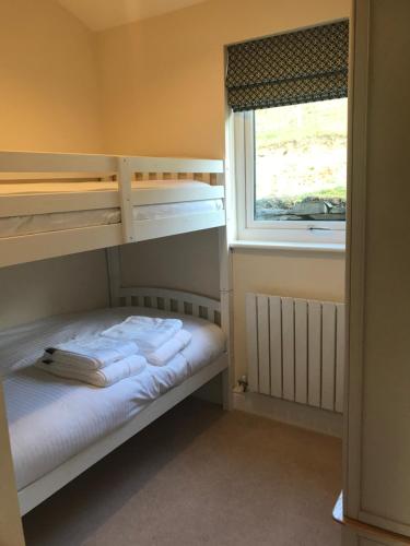 兰戈伦The Lodge的一间卧室设有两张双层床和一扇窗户。
