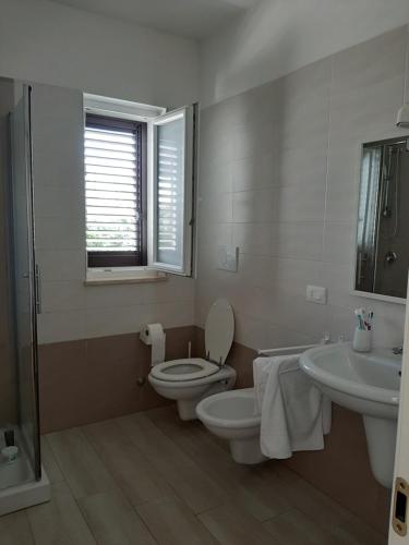 普尔萨诺Casa del Leccio的白色的浴室设有卫生间和水槽。