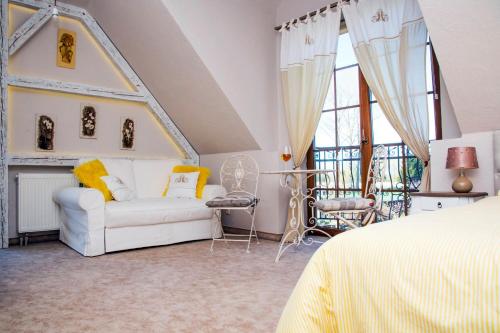 斯维诺乌伊希切Feniks Agro&Spa Adults Only的卧室配有白色沙发和椅子