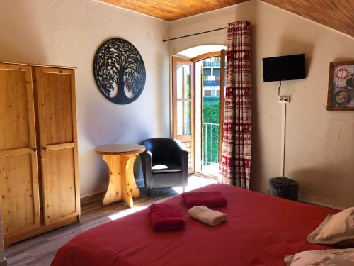 瓦尔Hôtel, Le Refuge Napoléon的一间卧室配有一张带红色毯子的床和窗户。
