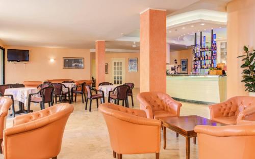 加提欧马里Hotel Spiaggia的一间带桌椅的餐厅和一间酒吧