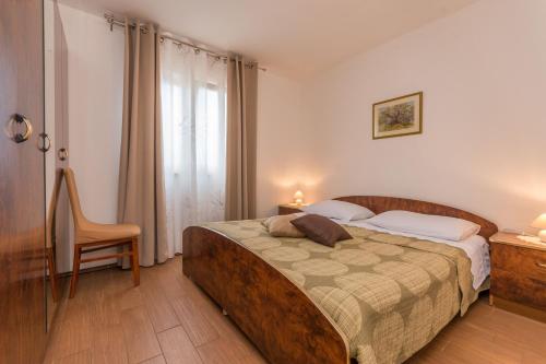 萨利Villa Sali的卧室配有床、椅子和窗户。