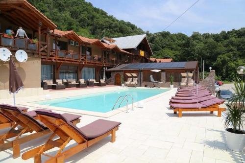 Moldova NouăPensiunea Deian-Clisura Dunării的一个带躺椅的游泳池的度假酒店