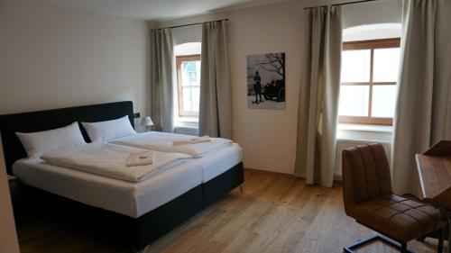 SchierlingHotelgasthof Kirchenwirt的卧室配有床、椅子和窗户。