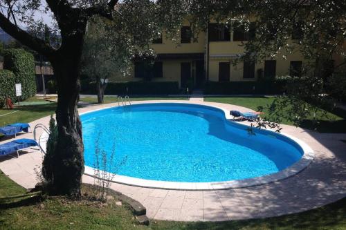 托斯科拉诺-马德尔诺Casa Mirella - Toscolano Maderno的一座大型蓝色游泳池,位于大楼旁边