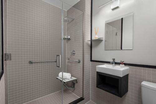 布鲁克林The Baltic Hotel的带淋浴、水槽和镜子的浴室