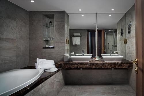 利默里克萨弗伊酒店的浴室配有2个盥洗盆、浴缸和浴缸。