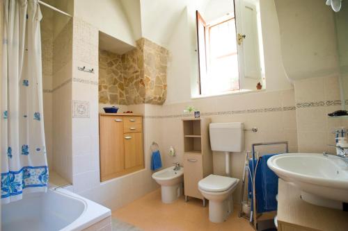 希克利Il Dammuso nel Vicolo的浴室配有盥洗盆、卫生间和浴缸。