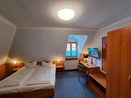 Peitz祖姆金狮酒店的一间卧室配有一张床、一张书桌和一台电视