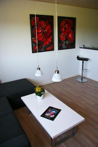 莱斯Gydensgaard ferielejligheder på Læsø的客厅配有咖啡桌和两幅画作