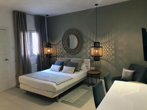 马德里六间房马约尔广场酒店的卧室配有白色的床和镜子