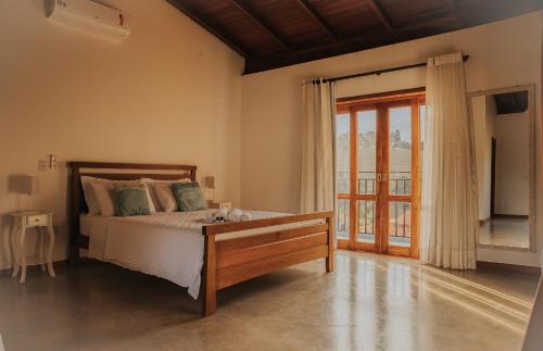 卡皮托利乌Pousada Cheiro da Terra的一间卧室设有一张床和一个大窗户