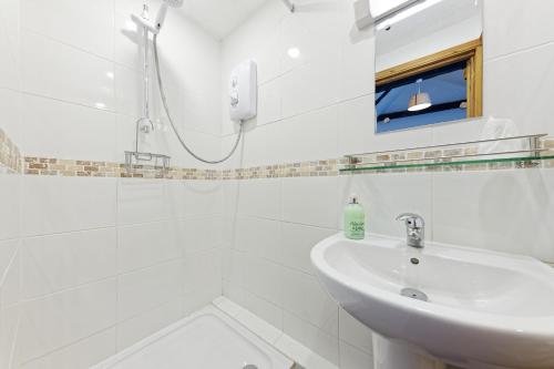 福克斯通Beachborough Park的白色的浴室设有水槽和淋浴。
