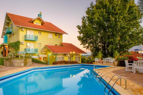 新彼得罗波利斯普萨达达内维酒店的房屋前有游泳池的房子