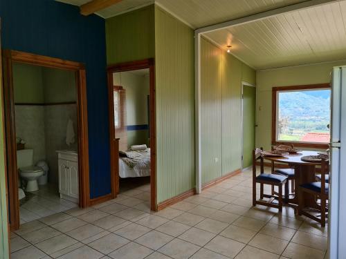 UjarrásVillas Valle Bello的客房设有桌子和1间配有1张床的浴室