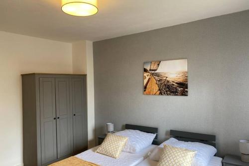 杜伊斯堡Gemütliche Wohnung zwischen Grün und Duisburg Hbf的卧室配有一张床,墙上挂有绘画作品