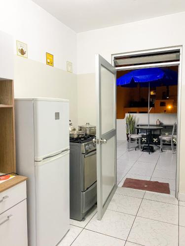 利马Apartamento Independiente 1 dormitorio cama Queen的一间带冰箱和开放式门的厨房