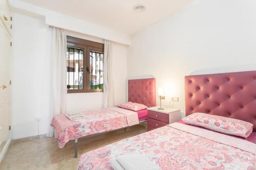 维拉科斯塔Appartement Orihuela Costa Golf, Las Ramblas的一间卧室设有两张床和红色床头板