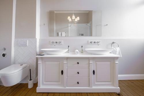 巴登-巴登Boutique Charme Apartment Ricarda的白色的浴室设有2个盥洗盆和1个卫生间。
