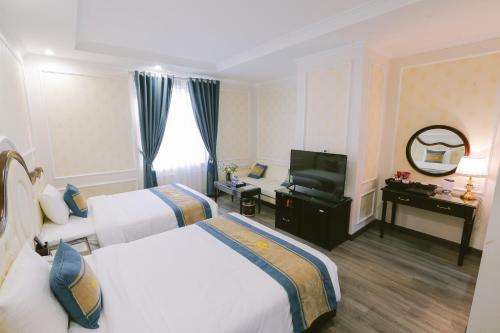 下龙湾Vincent Halong Hotel的酒店客房设有两张床和电视。