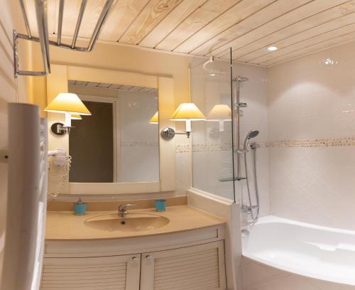 杜约特Logement avec terrasse sur lac, tout confort, dans résidence avec PLAGE et PONTON PRIVEE的一间带水槽、淋浴和镜子的浴室