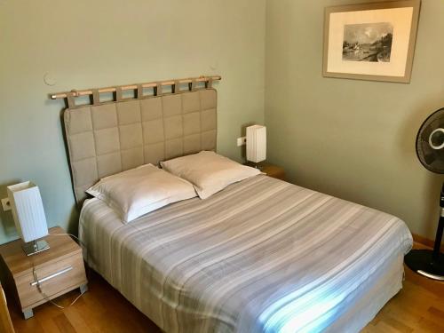里昂科特塞奥尼宾馆的一间卧室配有一张大床,桌子上放着两盏灯