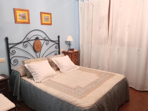 Santo Tomésol de membrillo的一间卧室配有一张带锻铁床头板的床