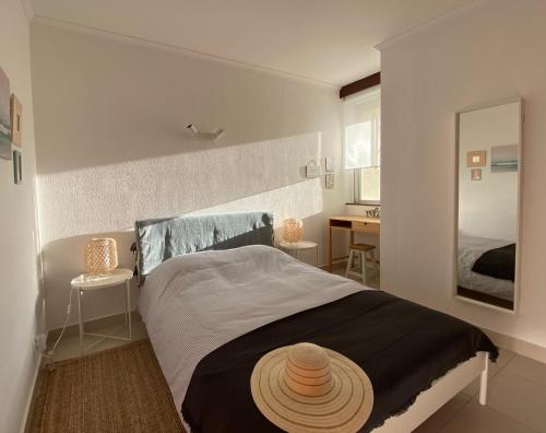 波尔蒂芒3 Castelos Sunset - Praia da Rocha的一间卧室,配有一张床,上面有帽子