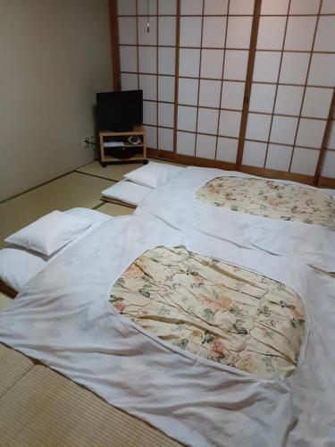 京都OHTO Ryokan的一间房间里三张床的组合