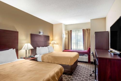 欧弗兰帕克Quality Inn Overland Park Kansas City的酒店客房设有两张床和一台平面电视。