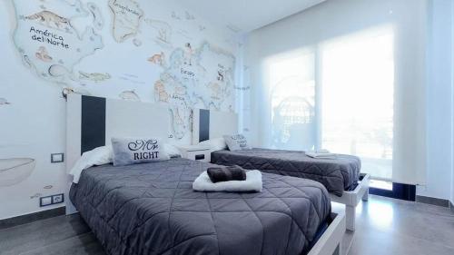 阿勒纳勒斯德尔索尔INFINITY VIEW Arenales的一间卧室设有两张床和一个大墙