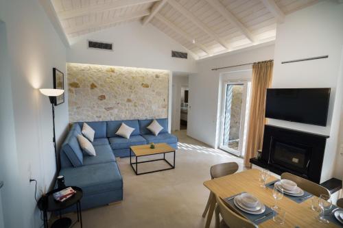 帕拉米夏Astrali Stone Villas的客厅配有蓝色的沙发和桌子