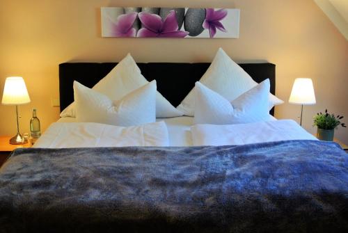 利兴Seehotel Lindenhof的卧室配有带白色枕头的大床