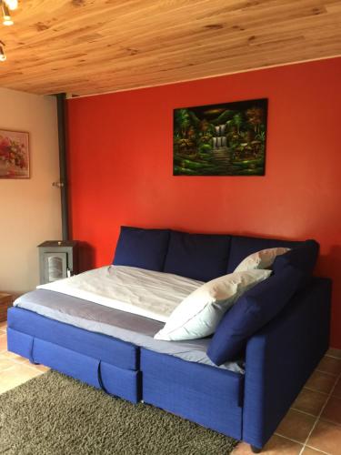 杜萨尔Lac d'Annecy的一间卧室配有一张蓝色的床和红色的墙壁