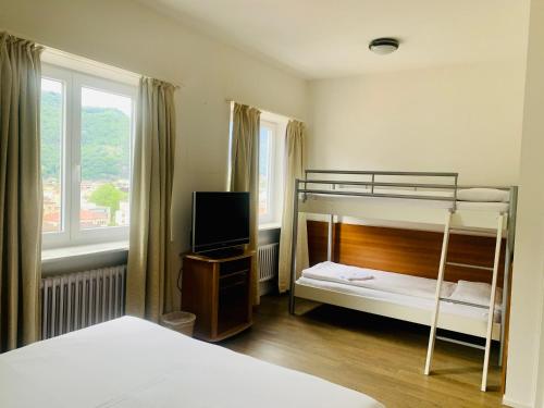 贝林佐拉甘珀酒店的一间卧室配有两张双层床和电视