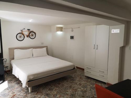 马蒂诺Black & White的卧室配有一张床,墙上有自行车