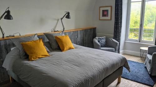 Saint-Cirgues-de-JordanneLa Maison Normande的一间卧室配有一张带黄色枕头的大床