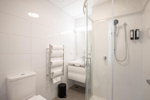 惠灵顿Sojourn Apartment Hotel - Riddiford的带淋浴和卫生间的白色浴室