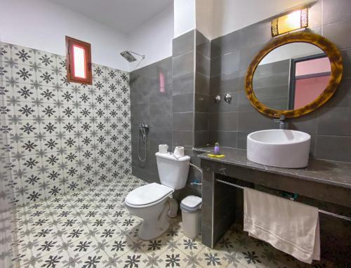 瓦尔扎扎特Hotel Riad Amlal的一间带卫生间、水槽和镜子的浴室