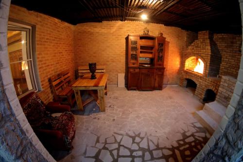 久姆里Vanand Guest House的客房设有木桌和壁炉。