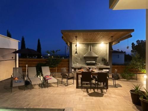 帕福斯Shanti Paphos Villa的一个带桌椅和烧烤架的庭院