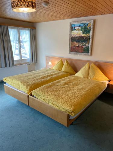 Sankt PeterzellLandgasthof Schäfle的一间卧室配有一张大床,提供黄色毯子和枕头
