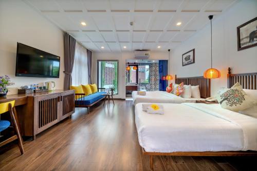 会安Son Trang Hotel Hoi An的酒店客房设有两张床和一台平面电视。
