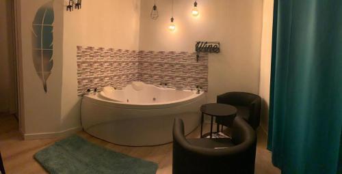 福尔米亚Luxury Suite Aurora的带浴缸、椅子和凳子的浴室