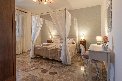 迪索NONNA VALERIA的一间卧室配有一张带窗帘和桌子的床