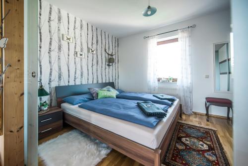 格罗森海恩Hussi's Home的一间卧室配有一张带蓝色床单的床和一扇窗户。